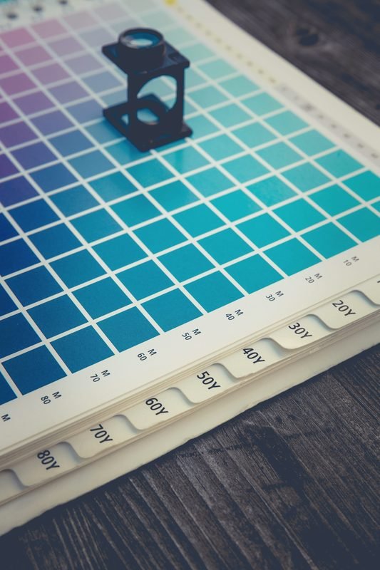 A printer's loupe resting on a sheet of color swatches